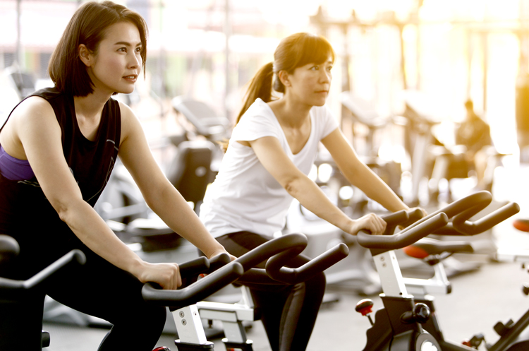 Two women on exercise bikes
