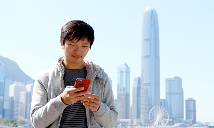Man on cell phone with cityscape in background