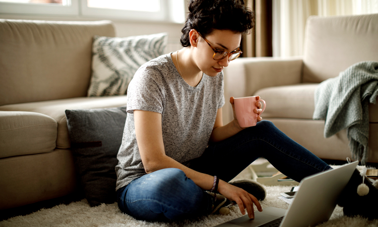 Woman sitting on living room floor with laptop